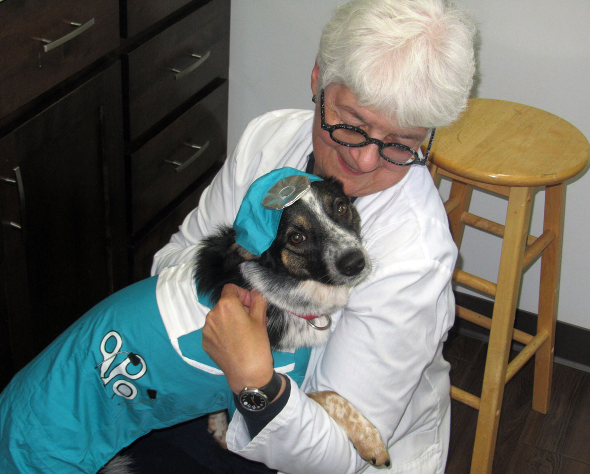 Dr. Claudia holding her dog who is in a Halloween costume